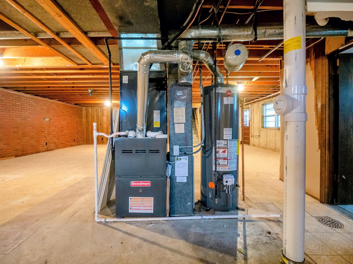 St. Louis home inspection — Goodman furnace and Rheem water heater in unfinished brick basement, the HVAC and mechanical systems every buyer should understand before making an offer