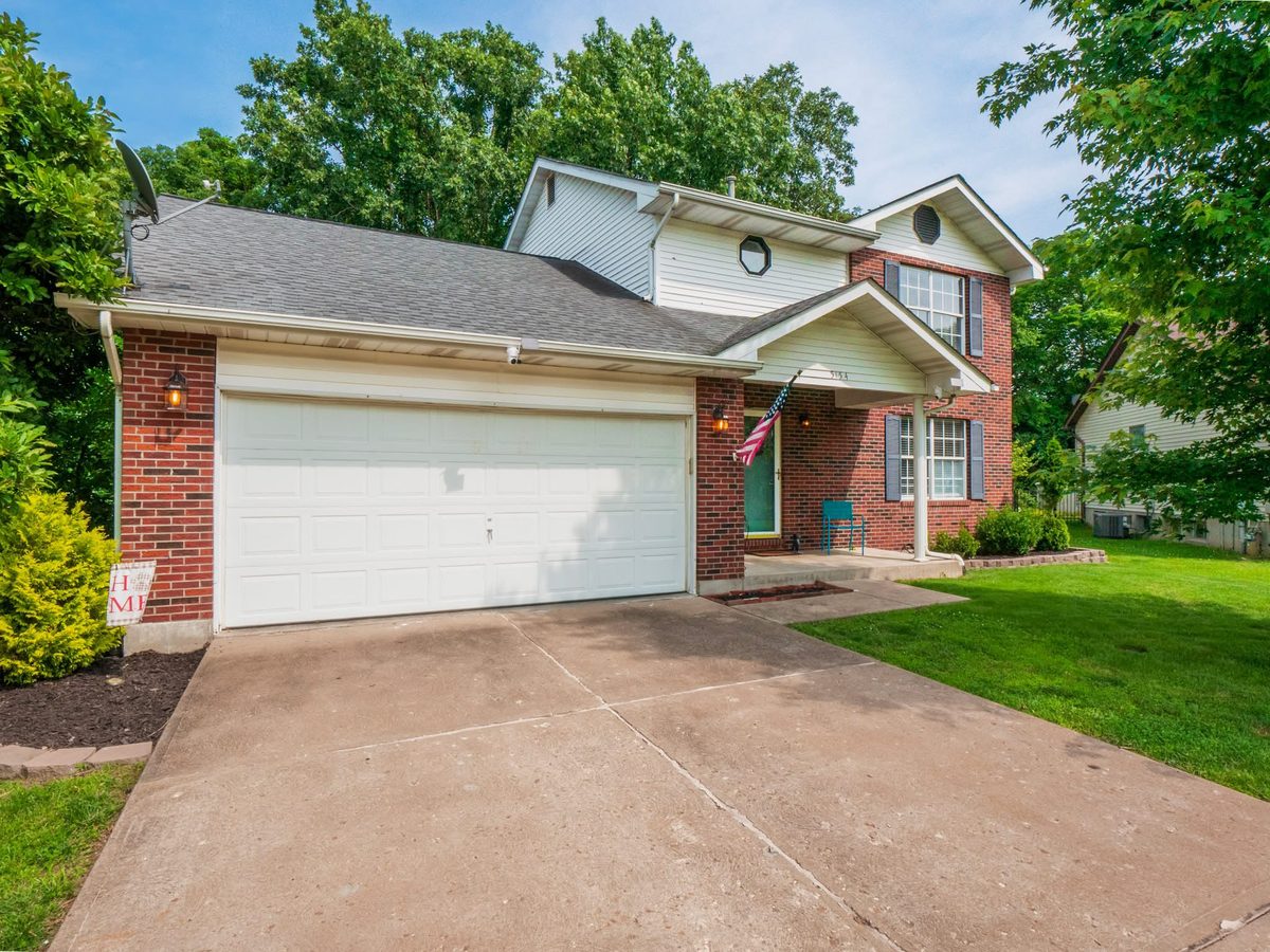 Two-story brick and vinyl home with a two-car garage and covered front porch at 5154 Autumn Ridge Drive in Imperial, Missouri