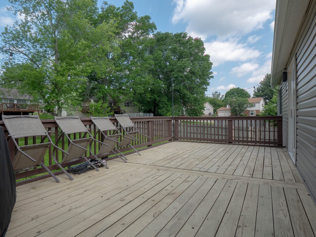 The back deck at 12945 Covington Gardens Drive, with string lights, patio chairs and a large yard behind it