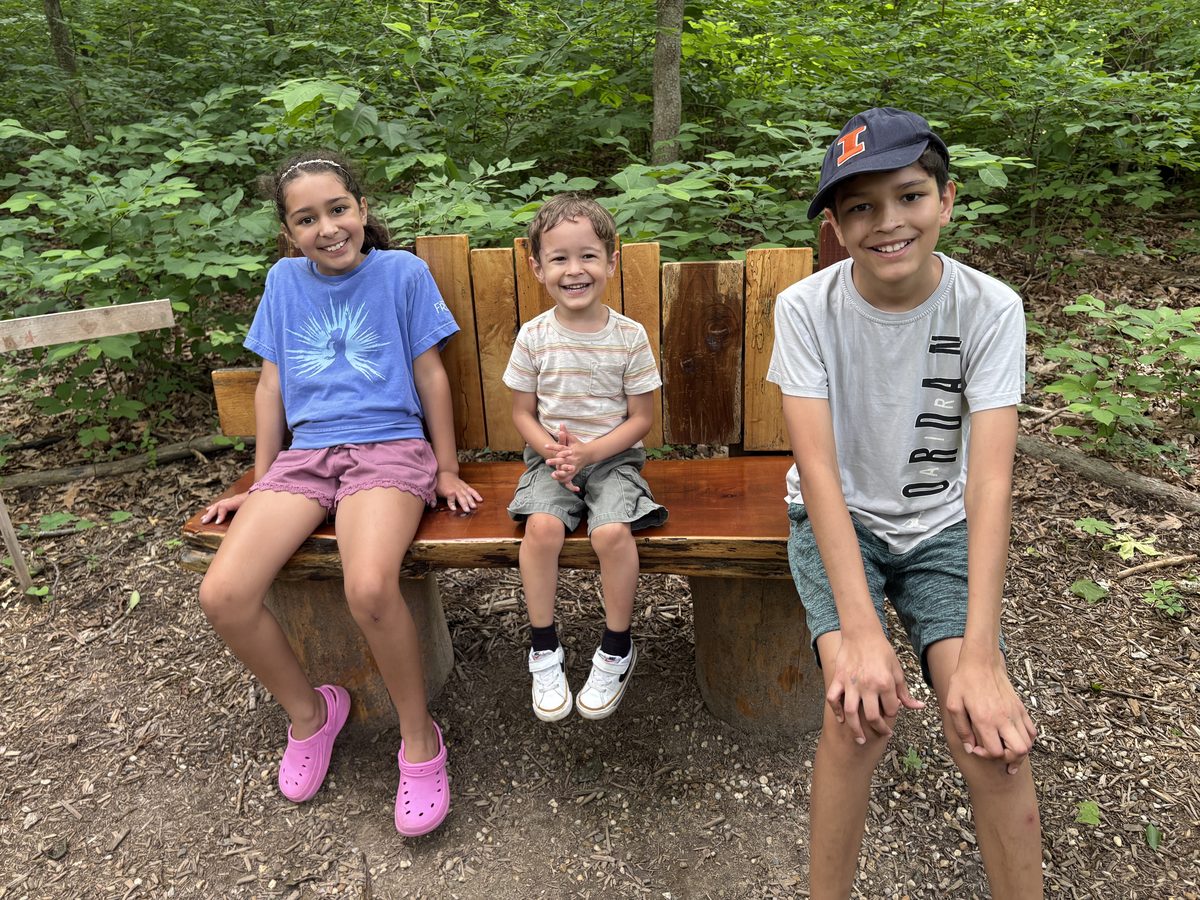 Bee Tree Park Oakville St. Louis — children on a bench on a wooded trail, the family outdoor lifestyle that draws buyers to Oakville and the 63129 South County corridor