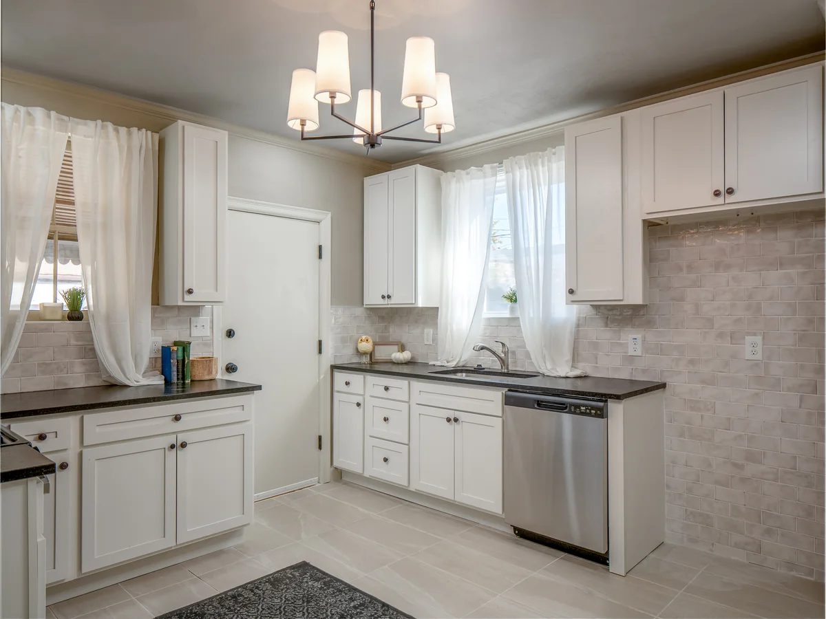 Updated kitchen — white shaker, dark counters, tile backsplash