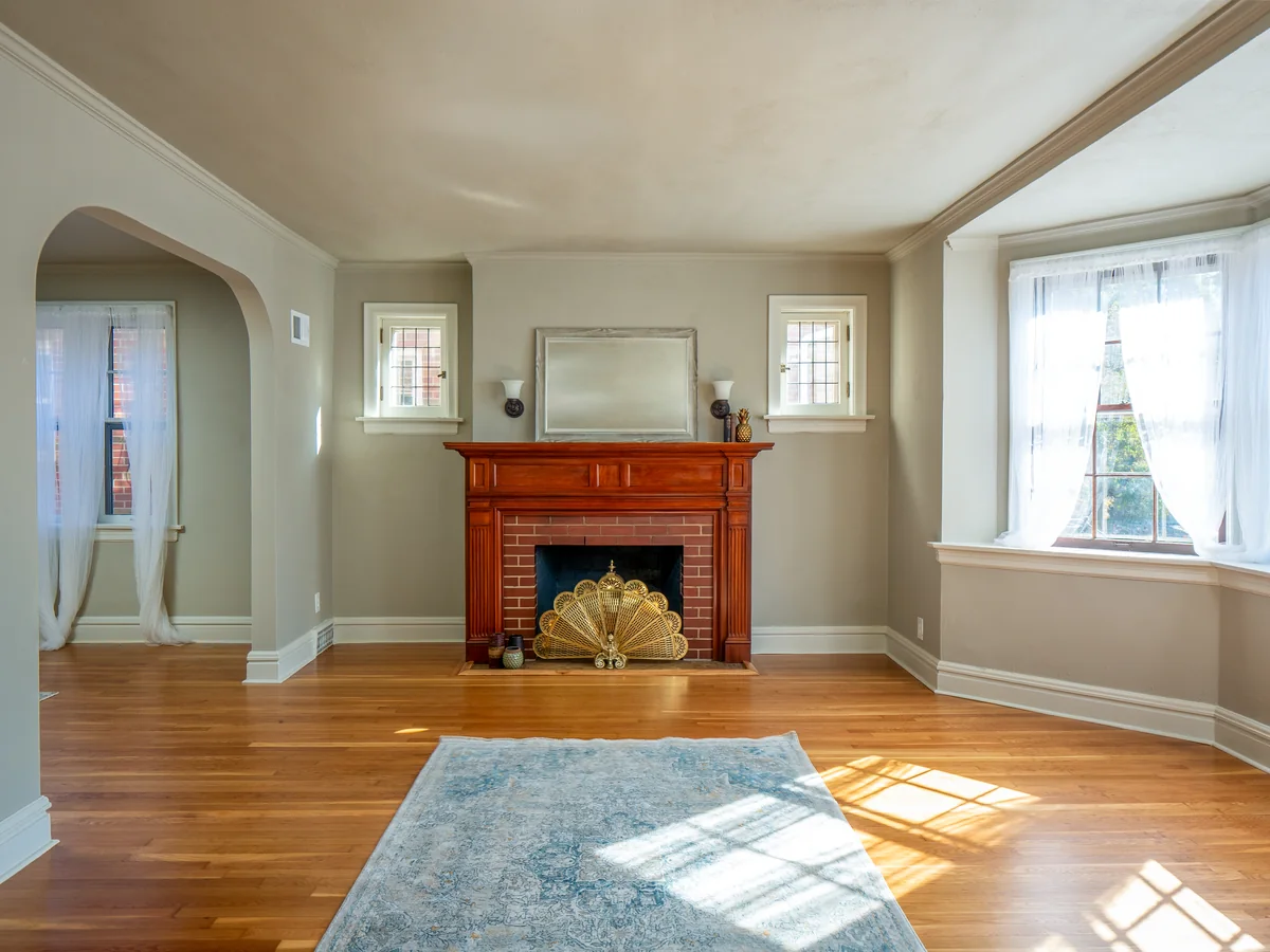 Living room — hardwood floors, brick fireplace, arch detail