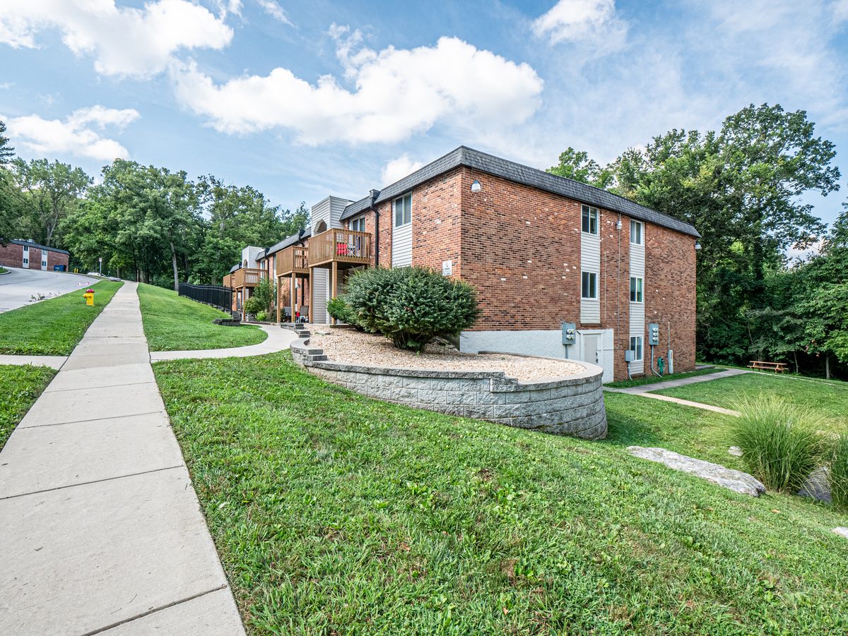 South County St. Louis attached housing — brick condo and townhome complex on wooded hillside, the non-single-family inventory buyers find in South County St. Louis County