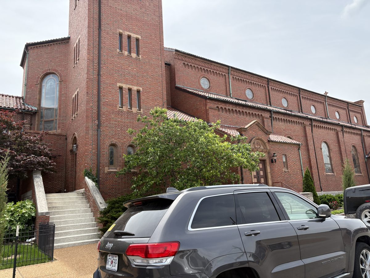 The Hill St. Louis homes for sale — Wilson Avenue streetscape with The Hill district sign, brick residential and Italian restaurants, 63110
